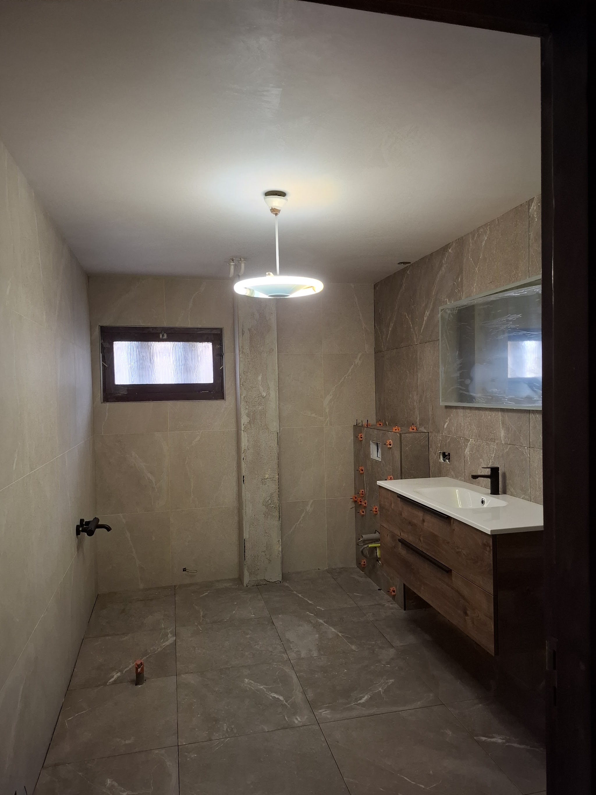 Afgewerkte badkamer met grote beige tegels