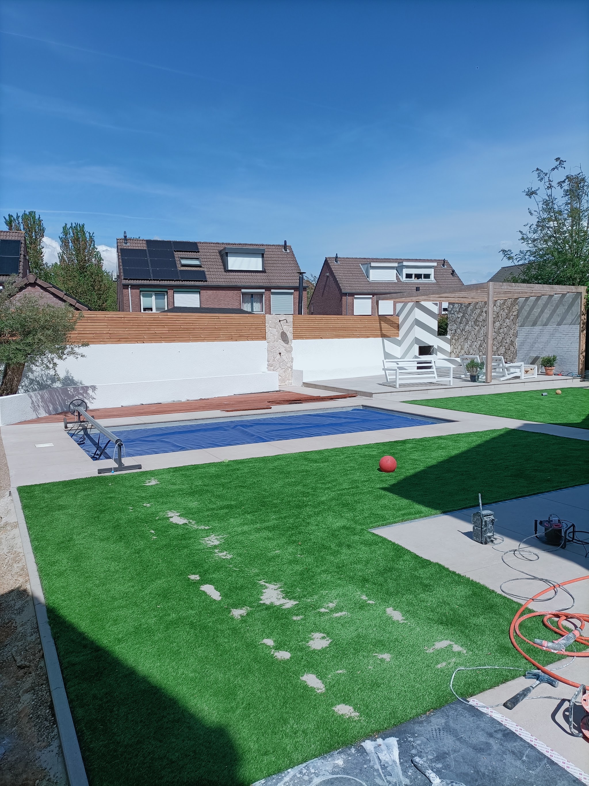Tuin met zwembad en wit gestuukte muren na afronding van het buitenwerk
